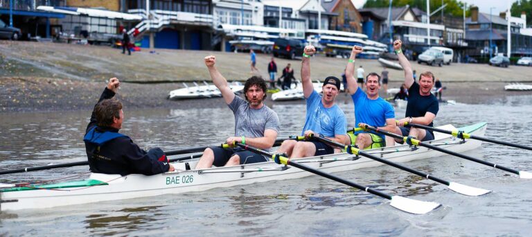 Team members rowing in unison during corporate team building activities focused on collaboration and coordination.