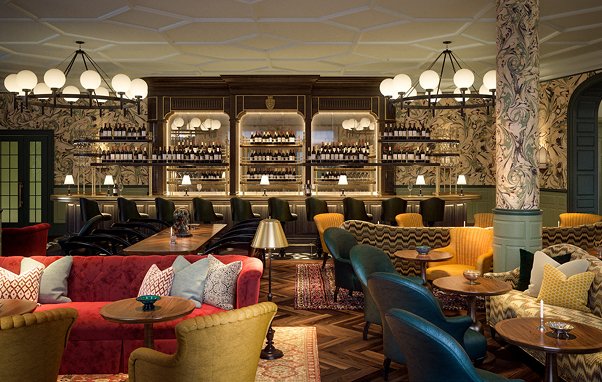 Upscale bar interior with wine bottles, chandeliers, sofas, and chairs. Elegant restaurant design.