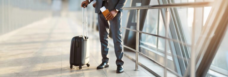 Business traveler with suitcase and passport. Corporate travel management.